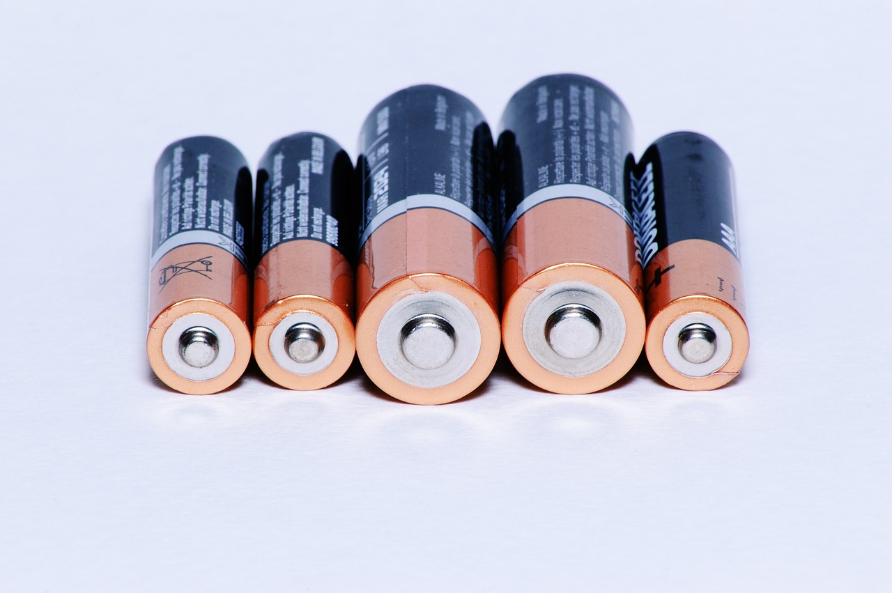 Row of household AA batteries on a white surface