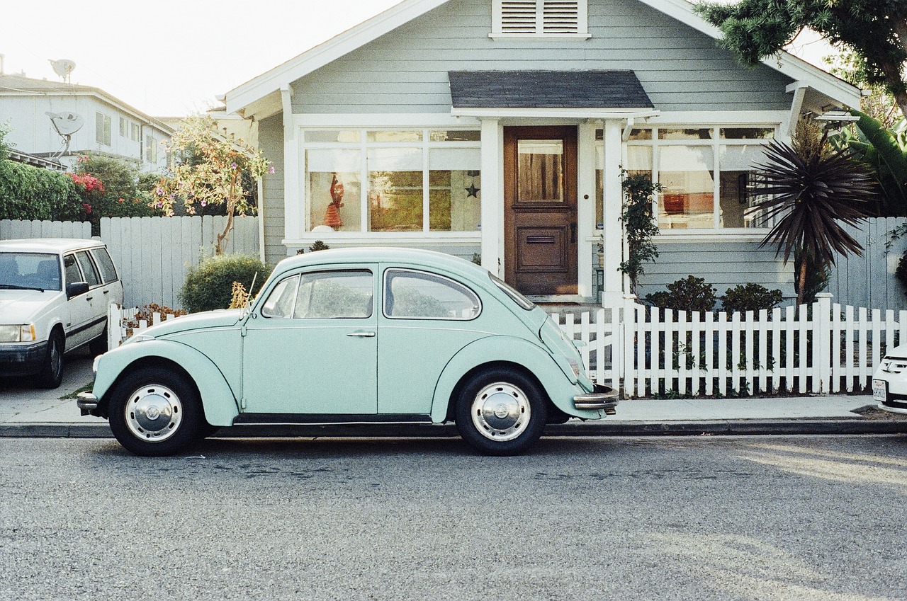 Older car parked at the kerb outside a suburban bungalow