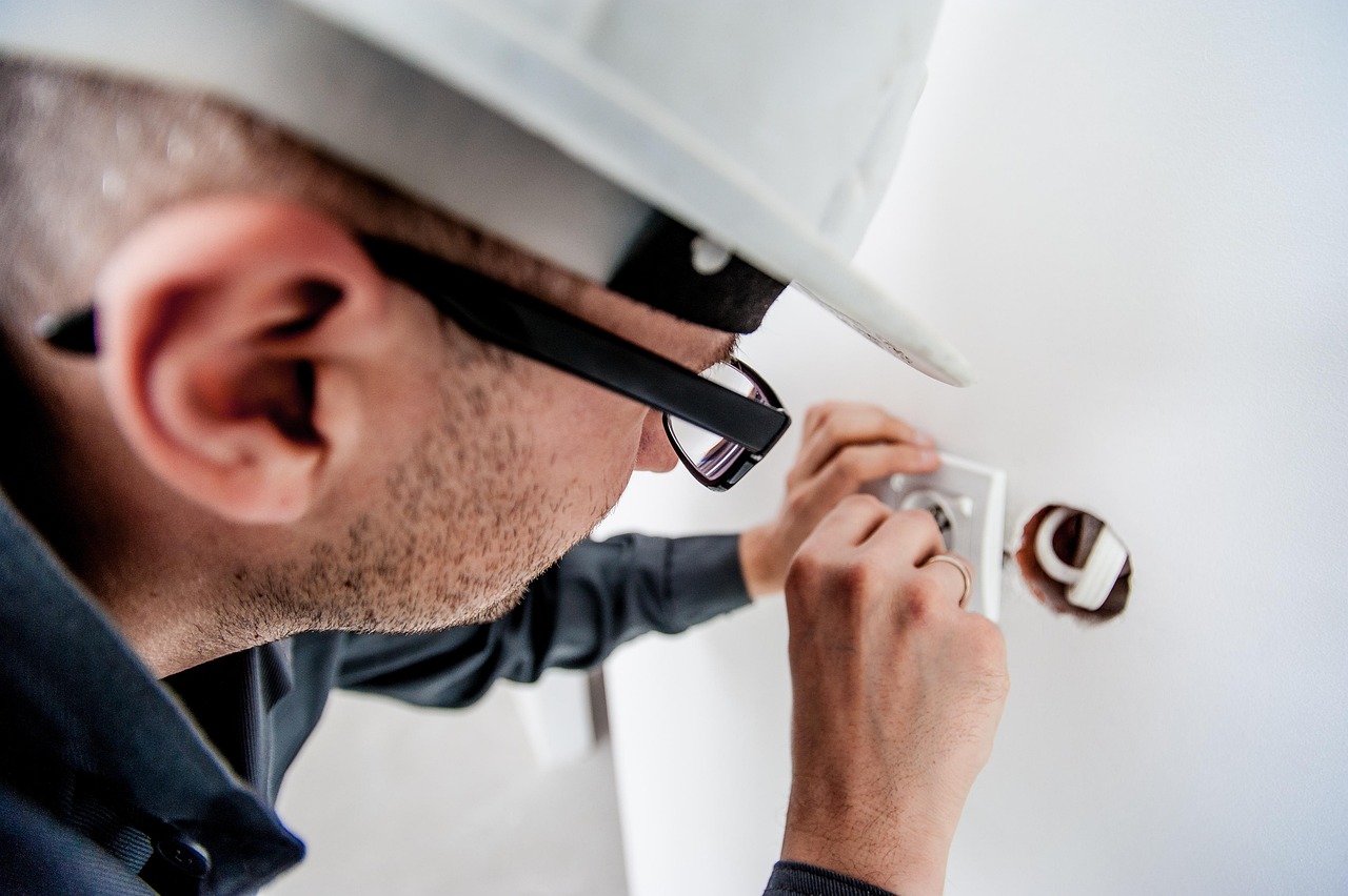 Electrician wiring a socket on an indoor wall